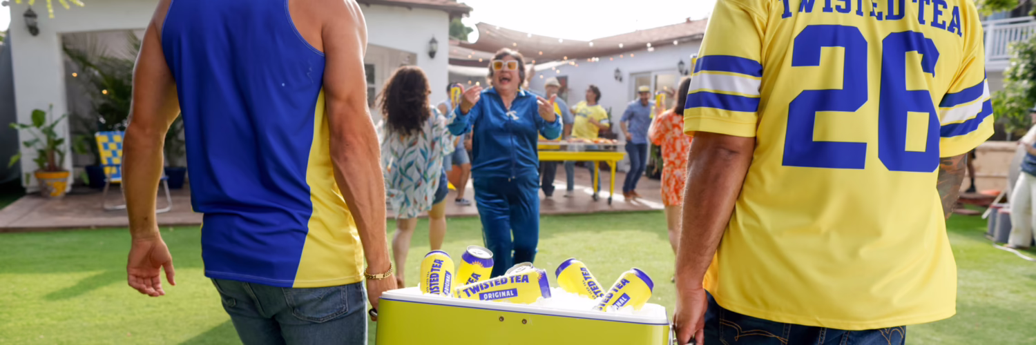 Des personnes transportent une glacière remplie de canettes de Twisted Tea lors d'un rassemblement extérieur.